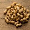In-shell groundnuts heaped on a wooden table